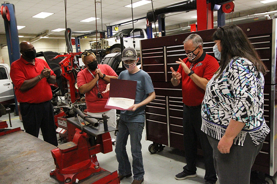 Zachary Hulett holding degree with faculty